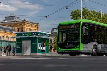 Ein ÜSTRA Bus steht auf der Straße vorm Hauptbahnhof, links daneben ist der ÜSTRA Servicepoint zu sehen, im Hintergrund der Hauptbahnhof. 