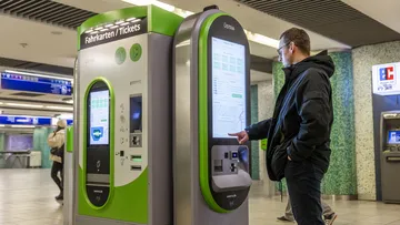Mann bucht Fahrtkarte am Fahrkartenautomat in der Station Kröpcke.