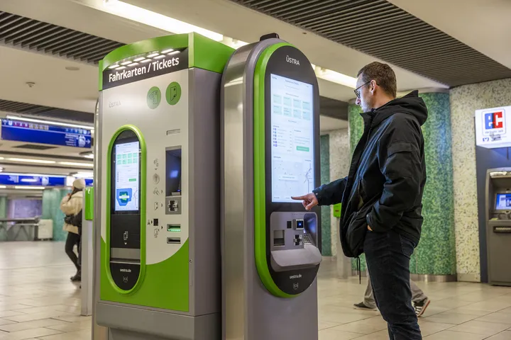 Male person purchasing a ticket at a vending machine