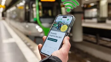 Handy wird vor Stadtbahn in Hannover in der Tunnelstation genutzt. Das Smartphone befindet sich im WLAN der ÜSTRA.