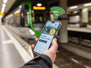 Handy wird vor Stadtbahn in Hannover in der Tunnelstation genutzt. Das Smartphone befindet sich im WLAN der ÜSTRA.
