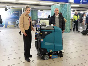 ÜSTRA Vorständin Elke van Zadel und protec Geschäftsführer Mathias Lindscheid präsentieren in der Station Kröpcke den neuen Wischroboter. Um sie herum stehen Menschen.