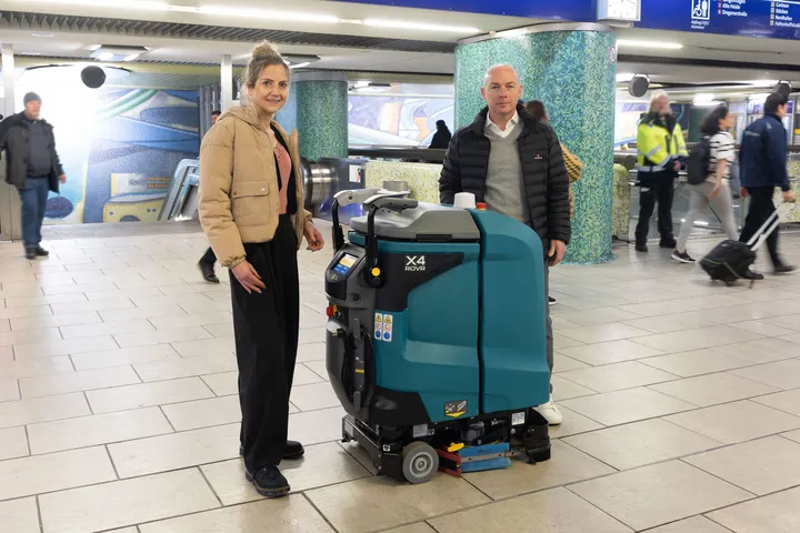 ÜSTRA Vorständin Elke van Zadel und protec Geschäftsführer Mathias Lindscheid präsentieren in der Station Kröpcke den neuen Wischroboter. Um sie herum stehen Menschen.