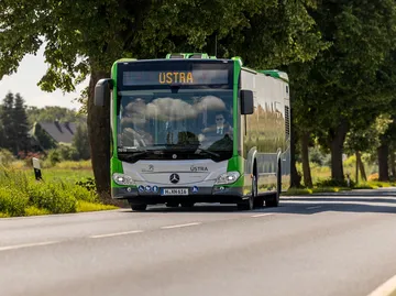 Ein Bus fährt auf einer Landstraße.