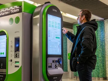 Ein Mann steht an einem ÜSTRA Fahrkartenautomat in der Station Kröpcke. 