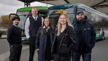 Fünf Mitarbeiter*innen von regiobus und ÜSTRA stehen vor einem regiobus und einem ÜSTRA Linienbus.