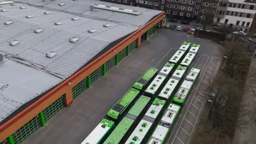 Die Fahrzeughalle des Betriebshof Vahrenwald und mehrere Busse vor der Halle aus der Luft von einer Drohne fotografiert.