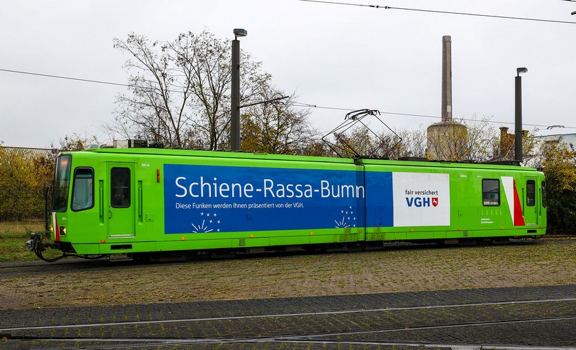 Der Schienenschleifer mit einer Beklebung "Schiene-Rassa-Bumm" steht auf einem Betriebshof.