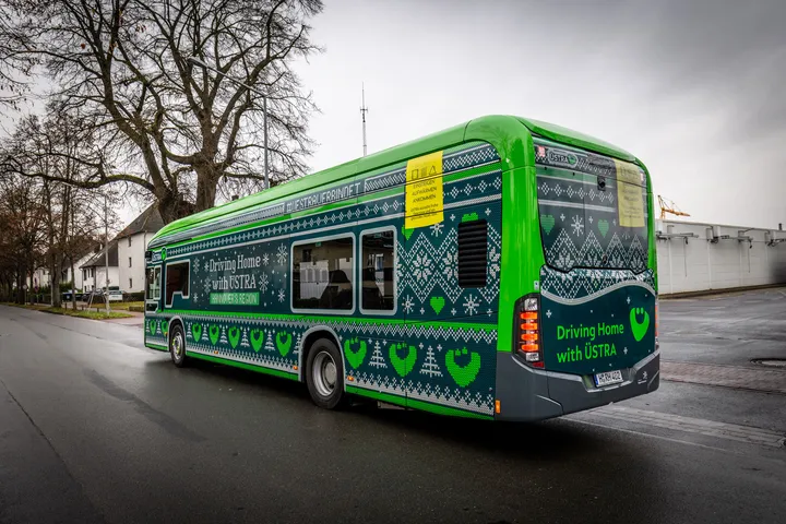 Das Winterdesign der ÜSTRA 2025 ist in einem Strickmuster gehalten. Ein Bus wurde damit vollflächig beklebt. Auf dem Bild sieht man das Heck und die Seitenansicht des Busses.