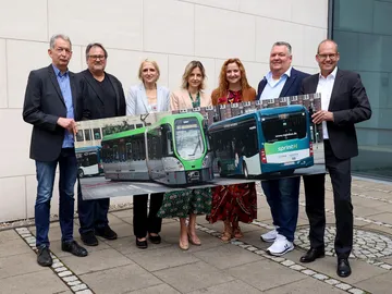 Auf dem Bild stehen folgende Personen vor einer Wand und halten ein großes Bild mit einer Stadtbahn und einem regiobus Bus in die Kamera (von links nach rechts): Rainer Weber, Betriebsratsvorsitzender regiobus, Wolfgang Toboldt, Aufsichtsratsvorsitzender regiobus, Regina Oelfke, regiobus Geschäftsführerin und ÜSTRA Vorständin, Elke van Zadel, regiobus Geschäftsführerin und ÜSTRA Vorstandsvorsitzende, Denise Hain, regiobus Geschäftsführerin und ÜSTRA Vorständin, Christian Bickel, Betriebsratsvorsitzender ÜSTRA und Ulf-Birger Franz, GVH Geschäftsführer