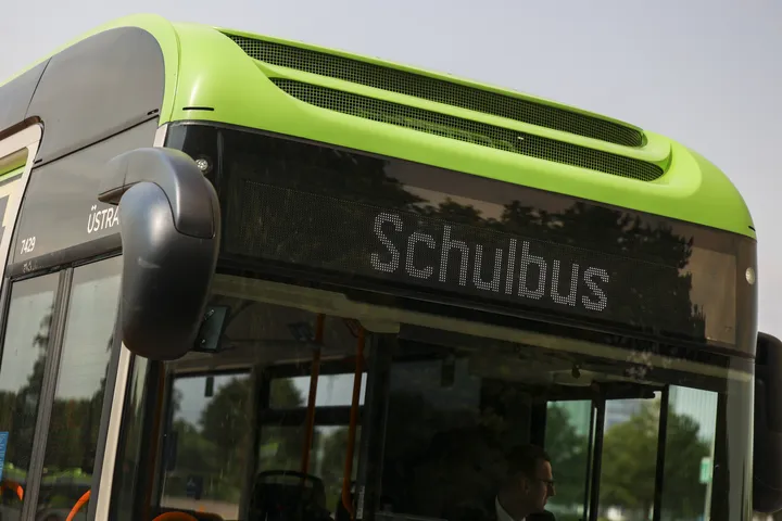 Zu sehen ist die digitale vordere Anzeige eines schwarzgrünen Busses. In der Anzeige steht "Schulbus".
