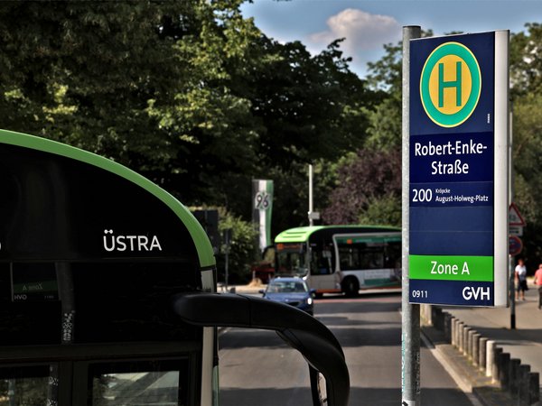 Ein ÜSTRA Bus neben dem Haltestellenmast "Robert-Enke-Straße".