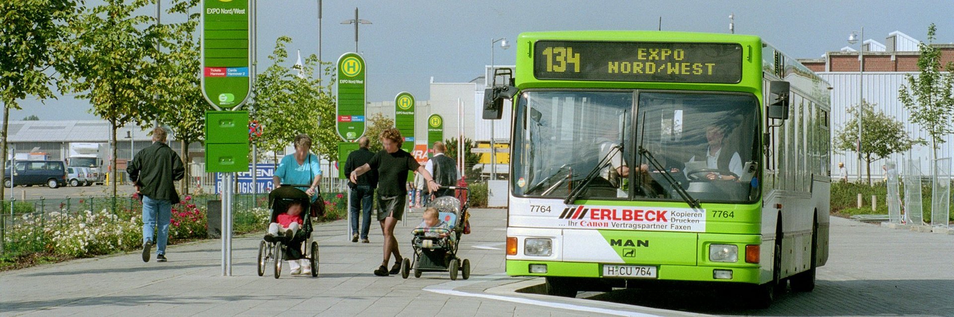 Ein MAN Bus mit Wagennummer 7764 steht an einer Haltestelle der Expo.