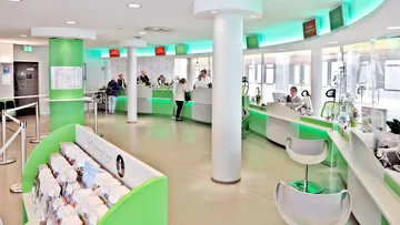 Aufnahme des Servicecenters der ÜSTRA mit mehreren Schaltern. Im Vordergrund sind Flyer zur Information zu sehen. 