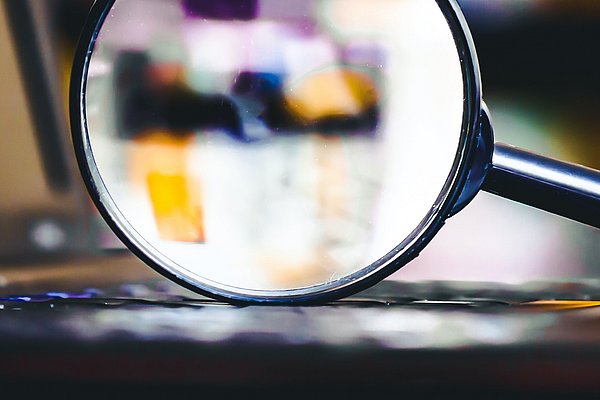 Detailpicture of a magnifying glass on a laptop