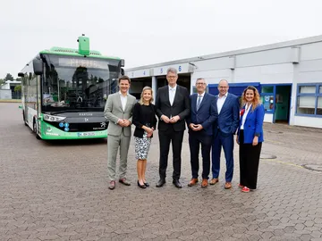 Regionspräsident Steffen Krach, ÜSTRA Vorstandsvorsitzende Elke van Zadel, Bundesverkehrsminister Patrick Schnieder, der Bürgermeister von Burgdorf, Verkehrsdezernent Ulf-Birger Franz und ÜSTRA Vorständin Denise Hain stehen vor dem albus. 