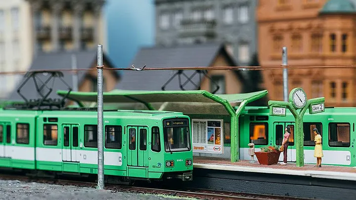 Modell einer Stadtbahn des Typ TW 6000 in grün an einer Modell-Haltestelle
